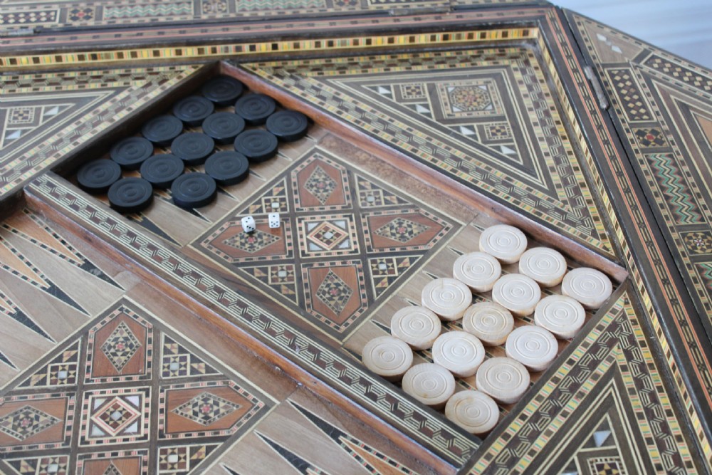 A 20th-century games table decorated with intricate geometric marquetry, mother-of-pearl inlay, and carved horseshoe arch aprons. View VI