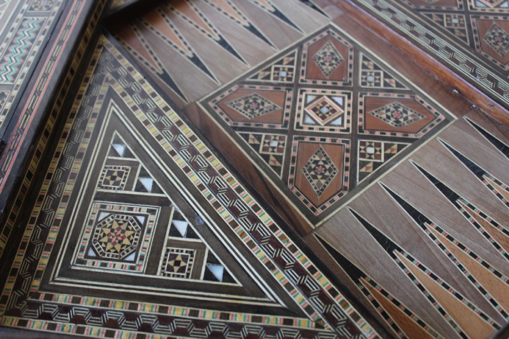 A 20th-century games table decorated with intricate geometric marquetry, mother-of-pearl inlay, and carved horseshoe arch aprons. View VII