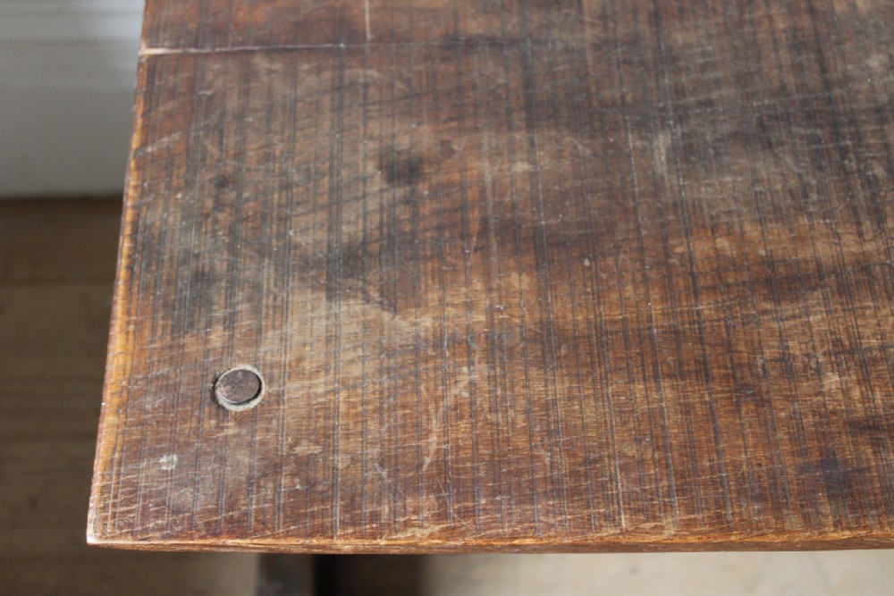 An 18th-century dark oak refectory table featuring a long rectangular top supported by shaped trestle end legs and a central horizontal stretcher. View IV
