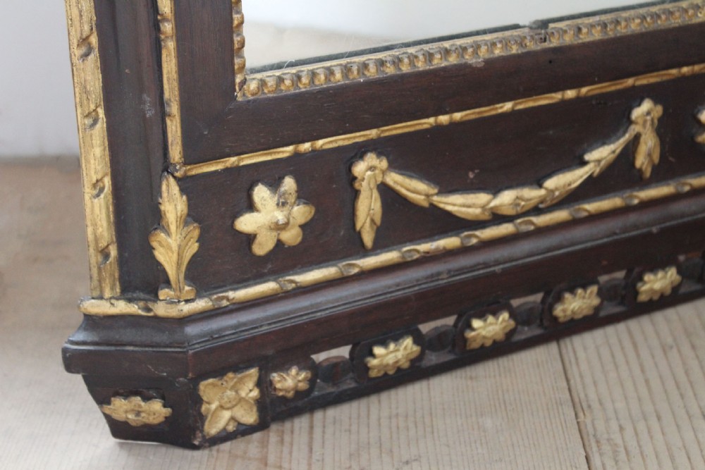 An 18th-century rectangular Neoclassical wall mirror featuring an ebonised frame adorned with carved giltwood festoons, rosettes, and an ornate cresting finial. View II