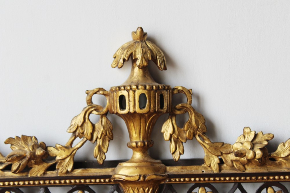 An 18th-century rectangular Neoclassical wall mirror featuring an ebonised frame adorned with carved giltwood festoons, rosettes, and an ornate cresting finial. View IV