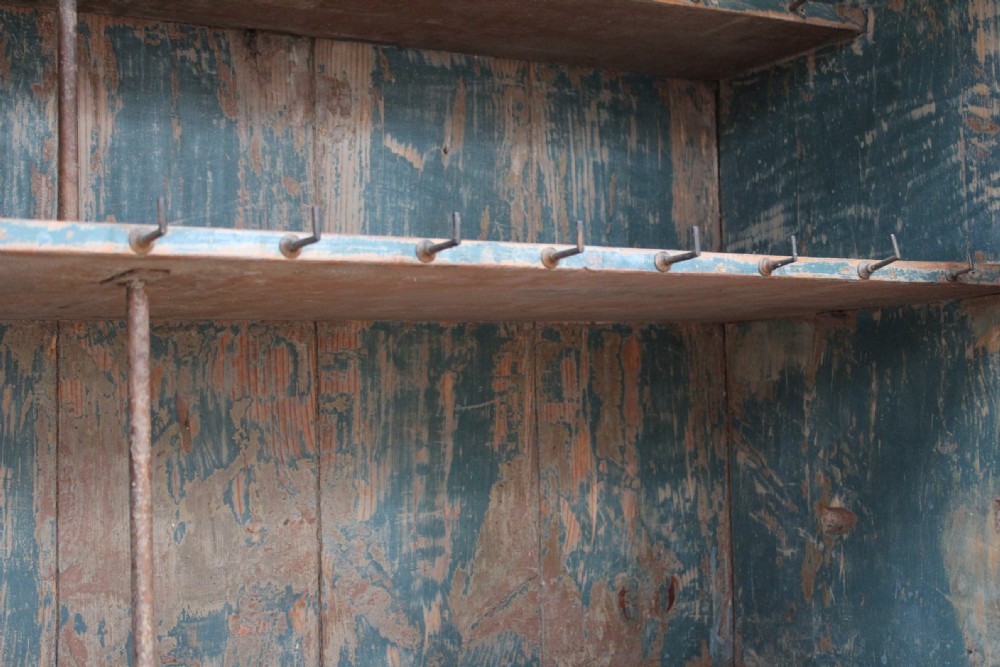 A 19th-century tall pine kitchen cupboard featuring a distressed blue painted finish, upper panelled doors, middle drawers, and lower cabinet doors. View VI