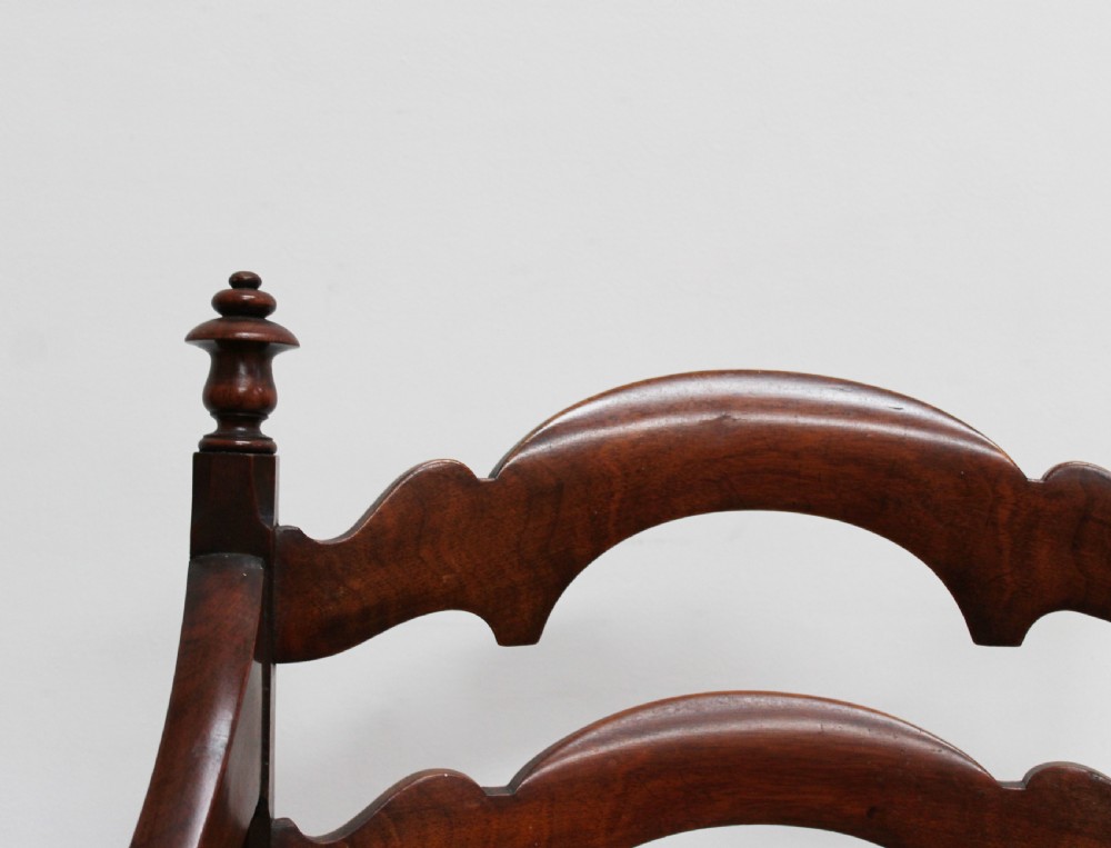 A pair of dark wood 19th-century X-frame armchairs featuring serpentine ladder-back splats, carved finials, and gold patterned fabric seats. View III