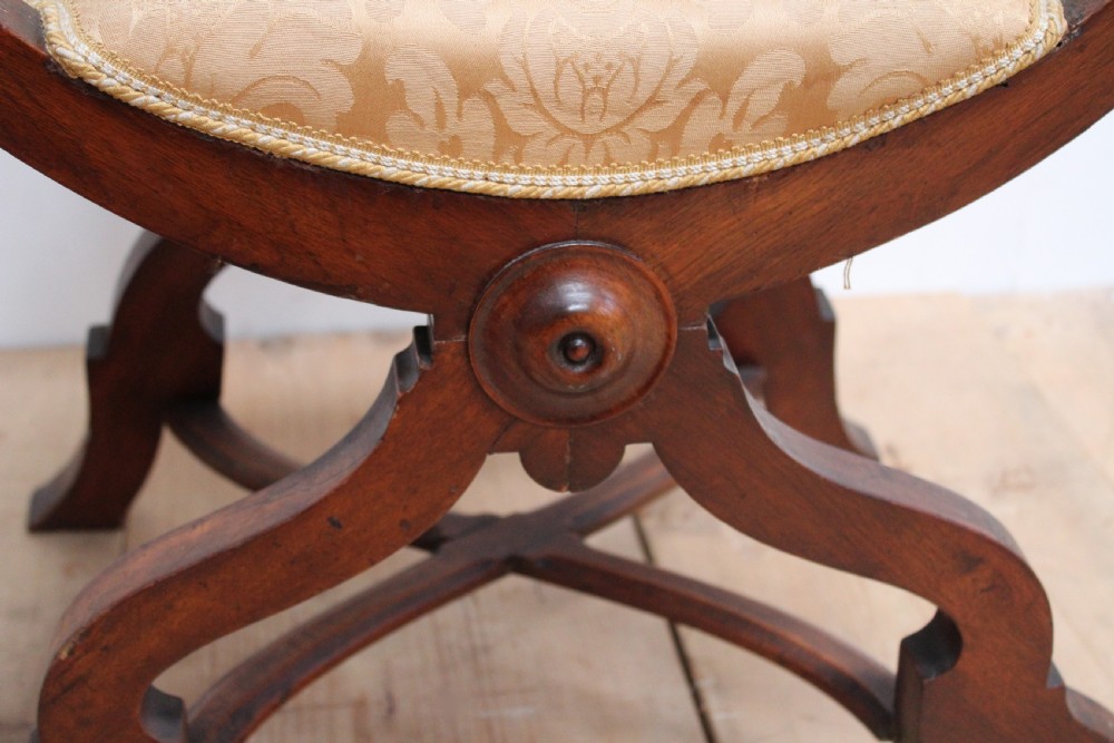 A pair of dark wood 19th-century X-frame armchairs featuring serpentine ladder-back splats, carved finials, and gold patterned fabric seats. View IV