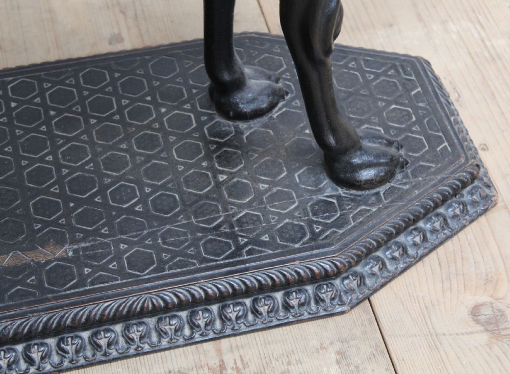 A dark carved wooden side table crafted in the form of a standing camel supporting a circular carved top on its saddle base. View III