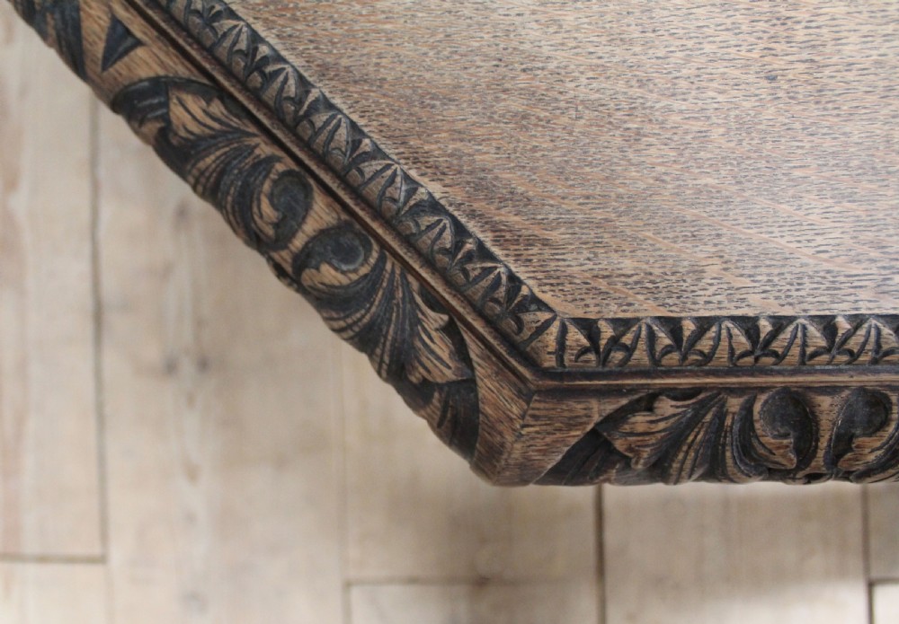 A 19th-century octagonal dark oak centre table with a carved foliate apron, turned columnar legs, an X-shaped stretcher, and carved paw feet. View V