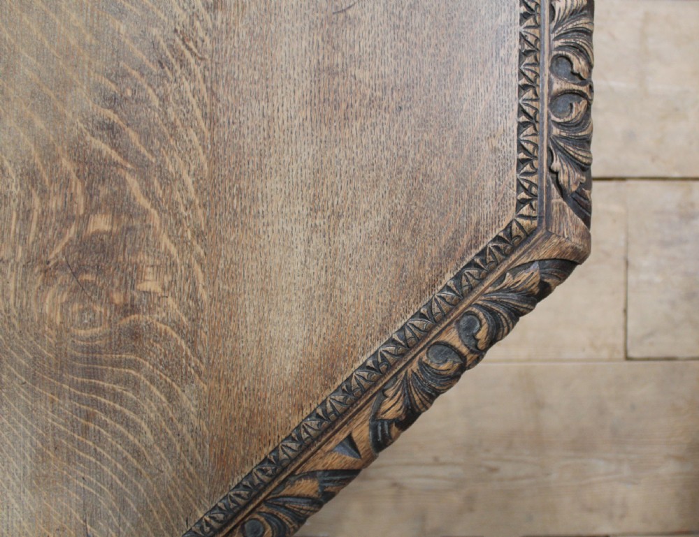 A 19th-century octagonal dark oak centre table with a carved foliate apron, turned columnar legs, an X-shaped stretcher, and carved paw feet. View VI
