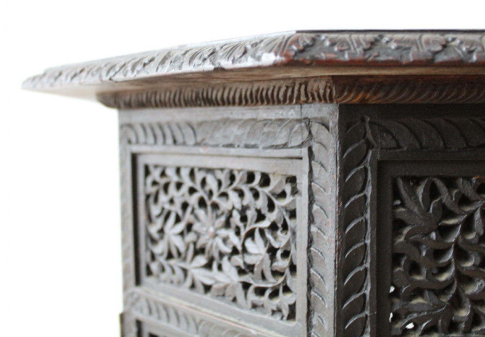 An octagonal dark hardwood side table featuring intricate openwork fretwork carving along the base and geometric borders surrounding a smooth central top. View II