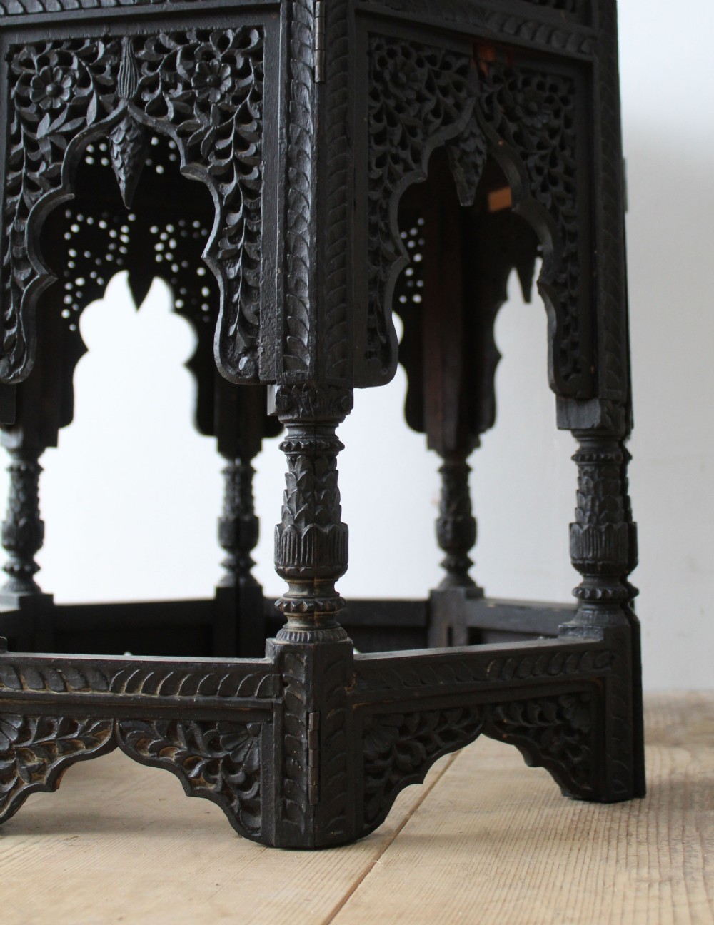 An octagonal dark hardwood side table featuring intricate openwork fretwork carving along the base and geometric borders surrounding a smooth central top. View III