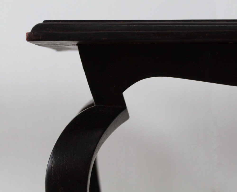 A pair of tall slender ebonised black wood console tables featuring outward-curving legs and square tops with lower stretchers. View II