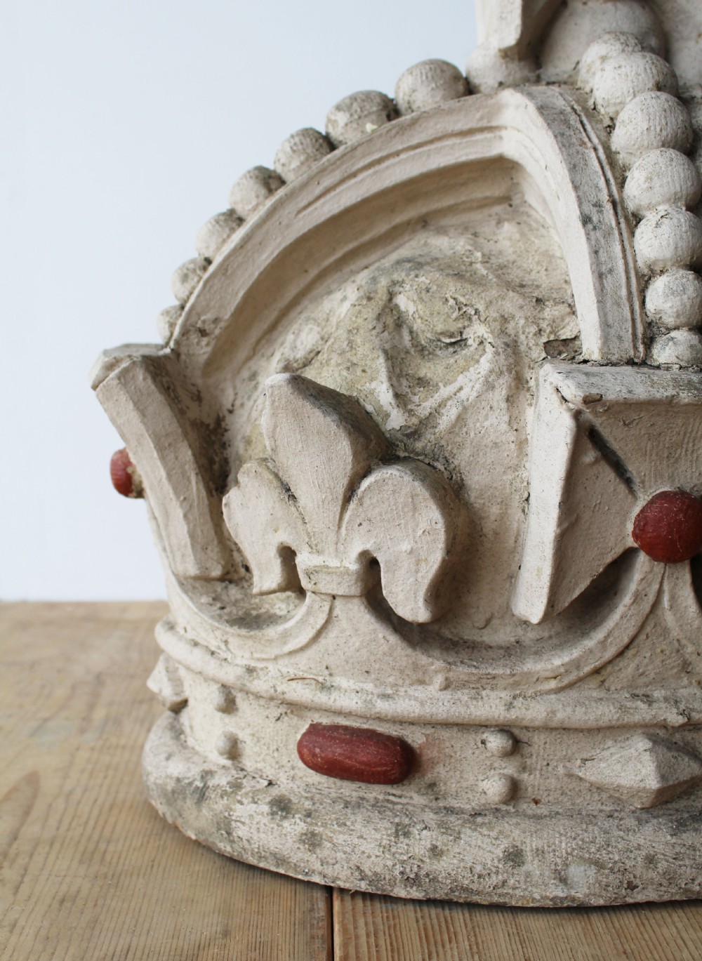 A large off-white carved composition stone crown sculpture featuring beadwork, fleur-de-lis motifs, and rounded red cabochon details. View II