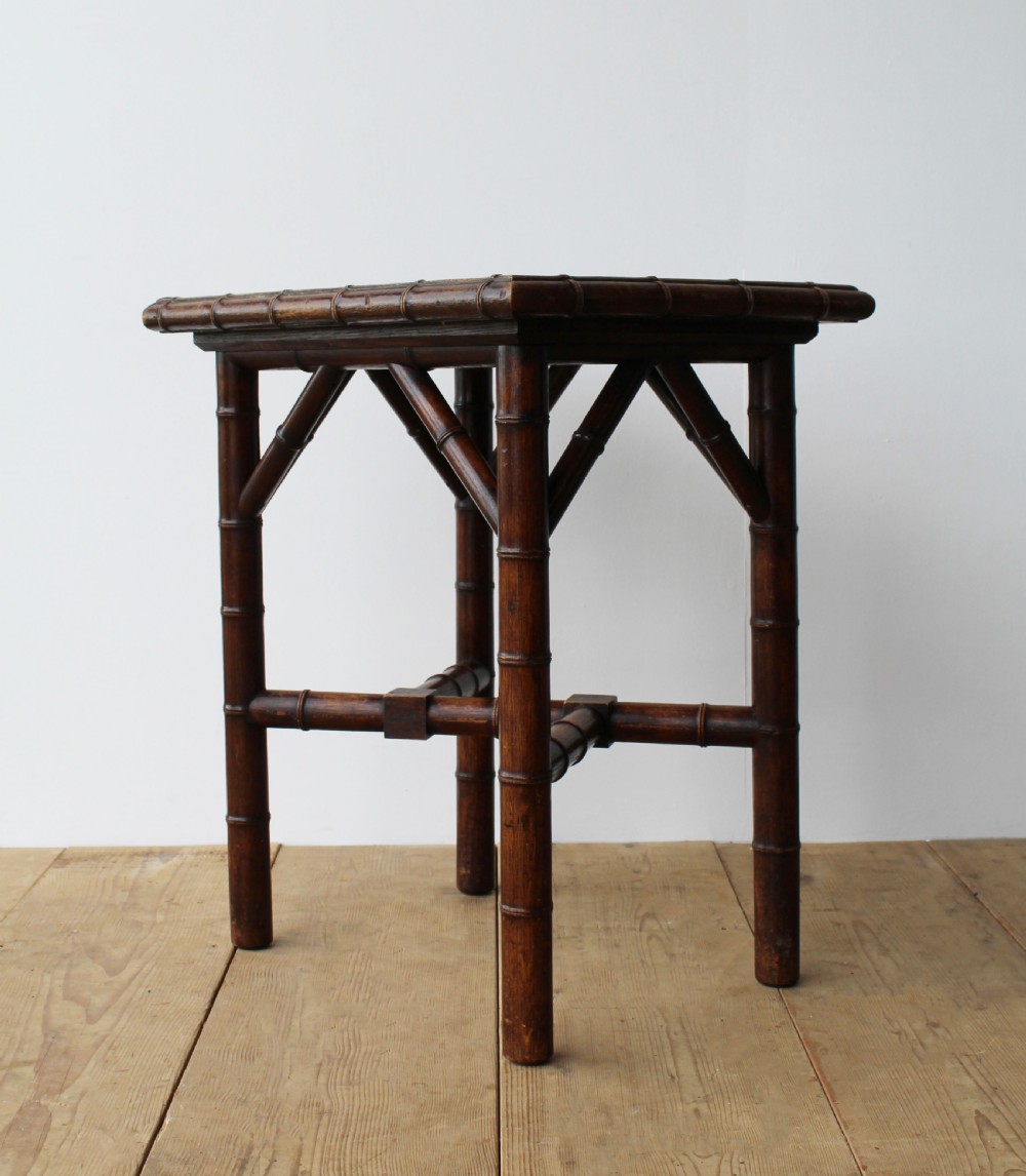 A late 19th-century dark bamboo lamp table featuring a square inset top lined with yellow and dark brown ceramic tiles and cross-braced legs. View II