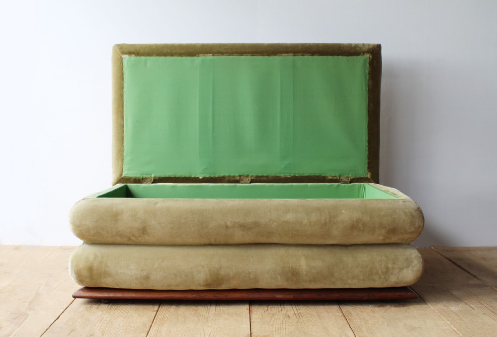 A large 19th-century tiered country ottoman with gold-green velvet upholstery, floral needlepoint top, and a wooden plinth base. View II