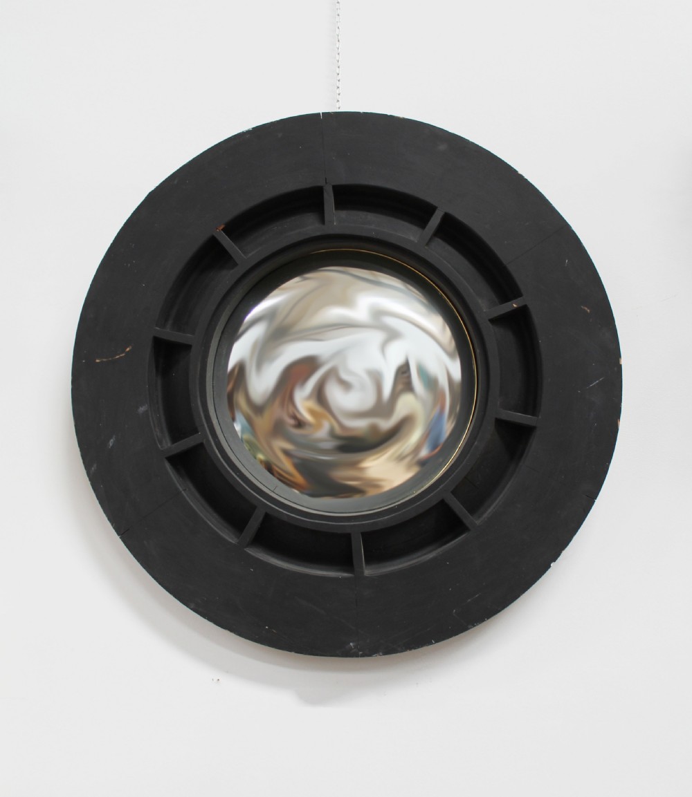 A circular ebonised wood wall mirror featuring a deep segmented frame and a central convex glass plate.