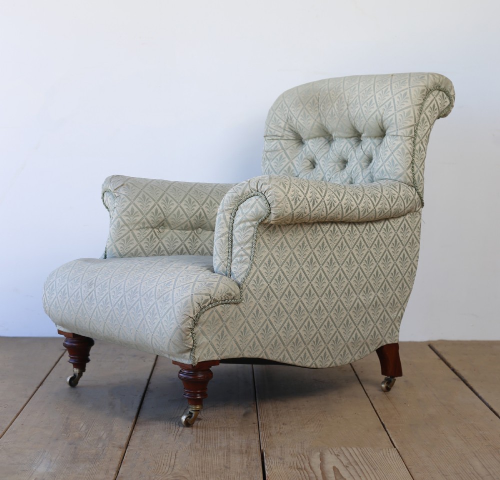 A Victorian button-backed armchair upholstered in sage green patterned fabric with scrolled arms, turned mahogany front legs, and brass castors. View IV