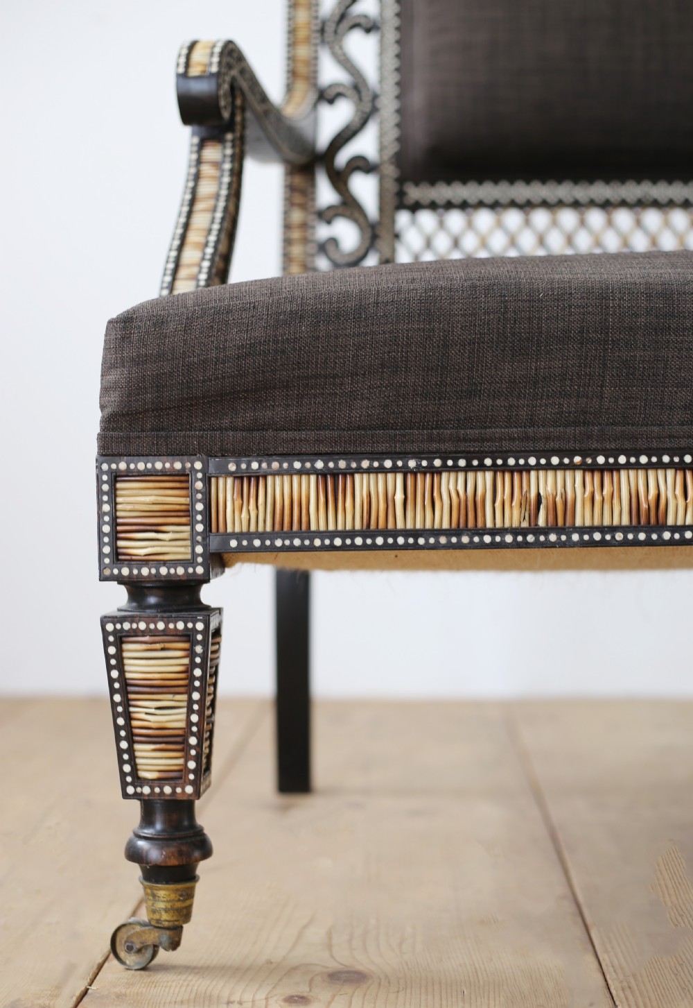 A nineteenth-century Anglo-Indian porcupine quill settee crafted from dark ebony wood with geometric bone dot inlay and dark brown fabric upholstery. View III
