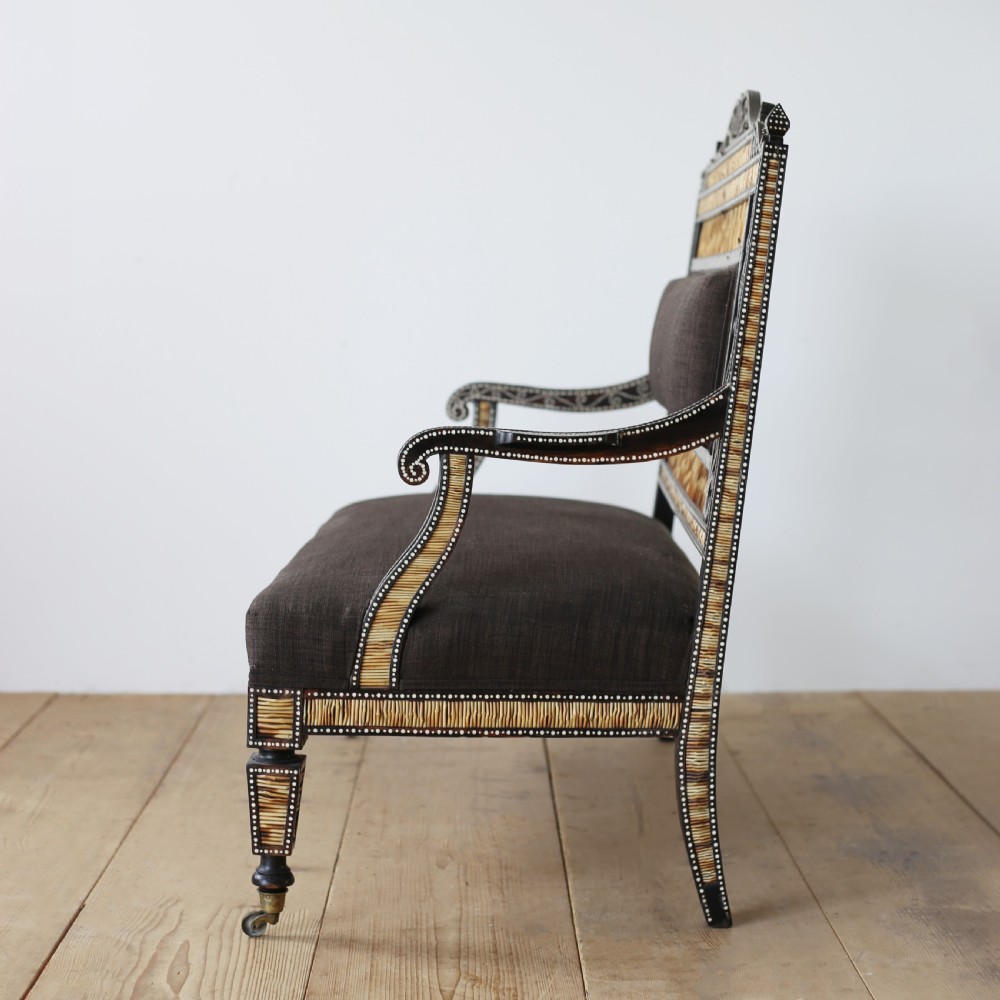 A nineteenth-century Anglo-Indian porcupine quill settee crafted from dark ebony wood with geometric bone dot inlay and dark brown fabric upholstery. View IV