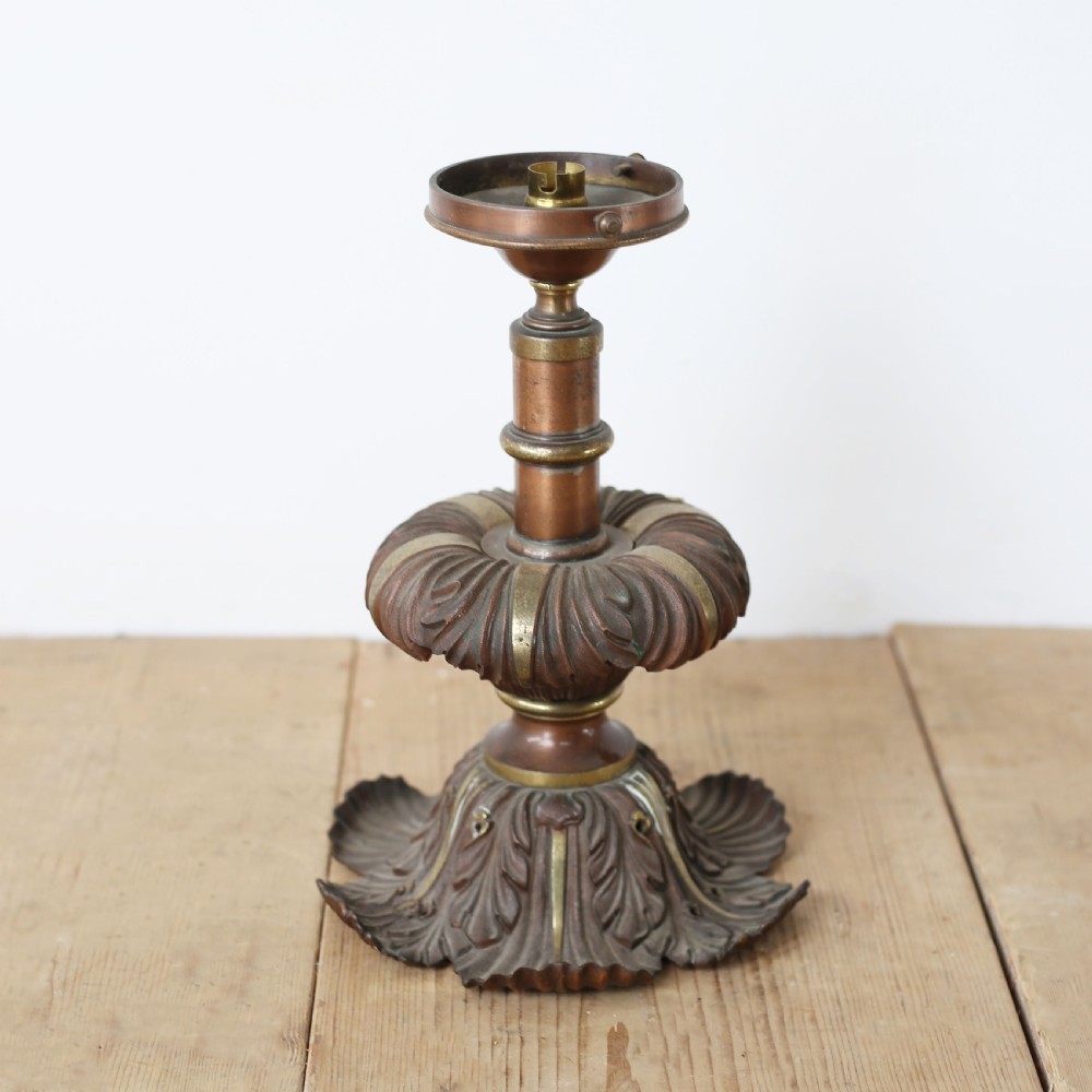 A pair of cast bronze and brass light bases featuring relief-carved acanthus leaf motifs and knopped central stems on a wooden surface. View II