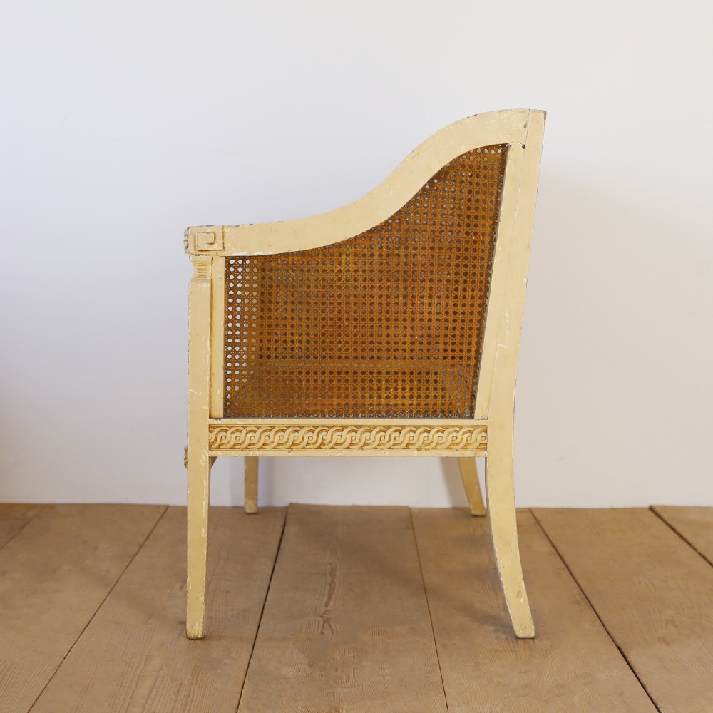 A cream painted wooden settee with a carved guilloche motif frame and woven cane back, side, and seat panels. View III