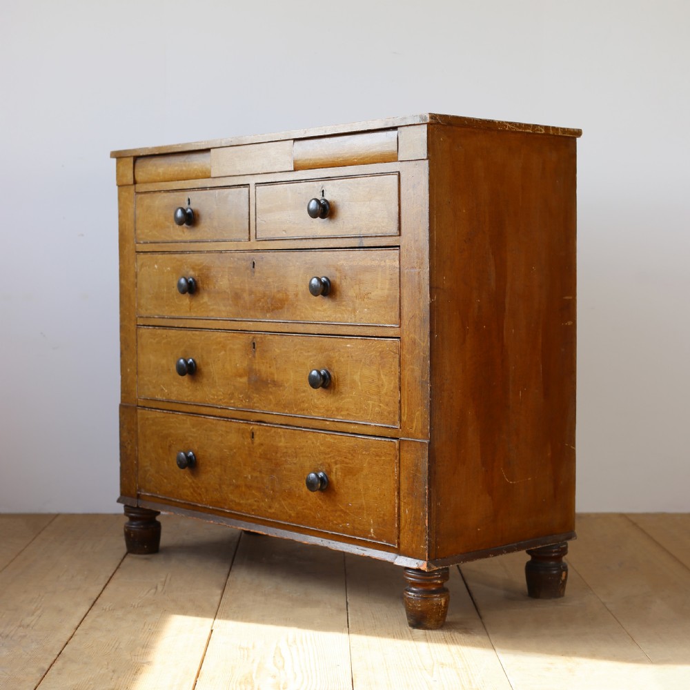 A 19th-century timber chest of drawers with turned wooden knobs and short turned feet. View IV
