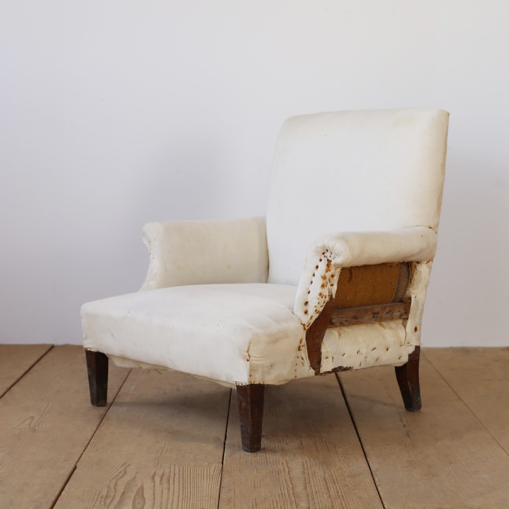 A 19th-century Howard style armchair upholstered in off-white calico fabric with exposed dark wood tapered front legs and brass studding along the scrolled arm fronts. View III