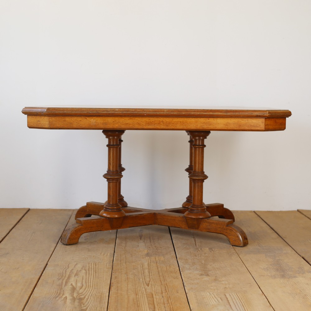 A 19th-century oak centre table featuring a canted-corner top supported by turned pillars and an X-shaped cross-stretcher base. View II