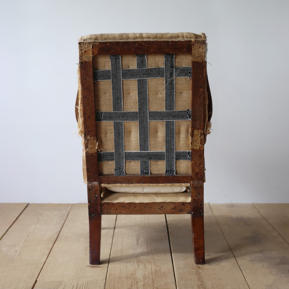 A 19th century wingback armchair presented in hessian upholstery with dark turned front legs and a off-white cushion. View V