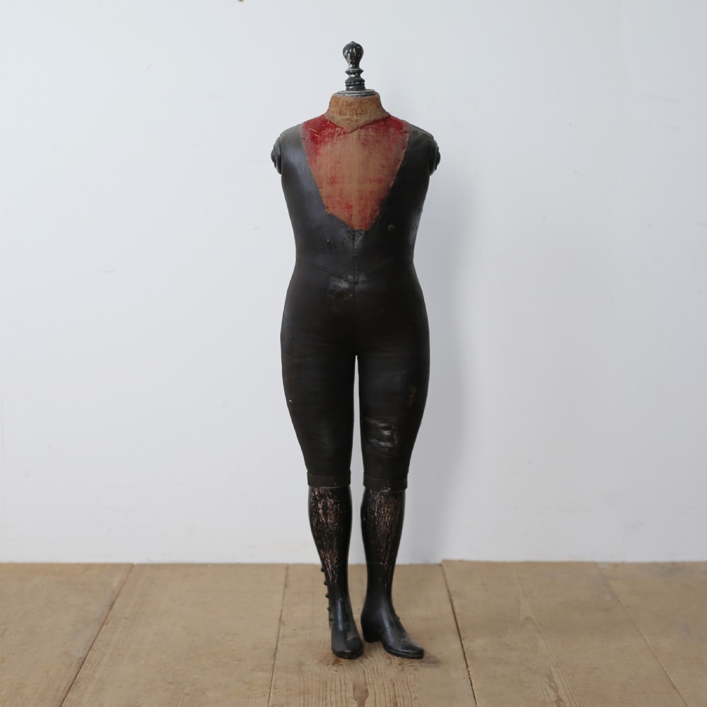 A 19th-century full-body standing tailor mannequin featuring a dark grey body with a contrasting reddish fabric chest insert and a turned top finial.