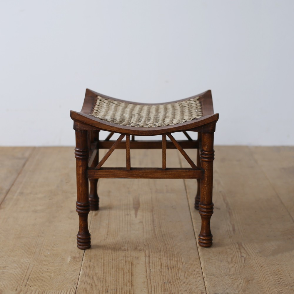 A pair of dark wood stools featuring concave woven cord seats and turned legs with diagonal spindled stretchers. View II