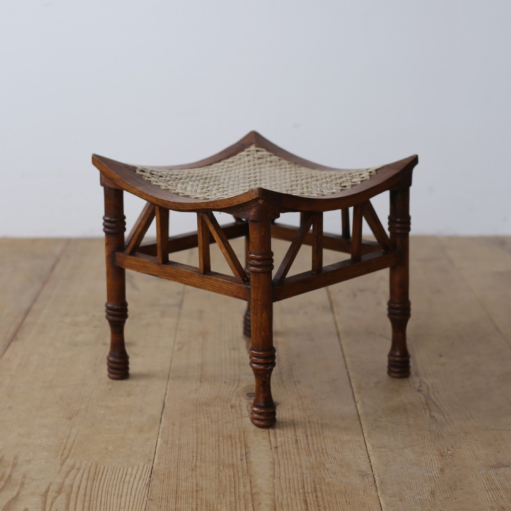 A pair of dark wood stools featuring concave woven cord seats and turned legs with diagonal spindled stretchers. View III