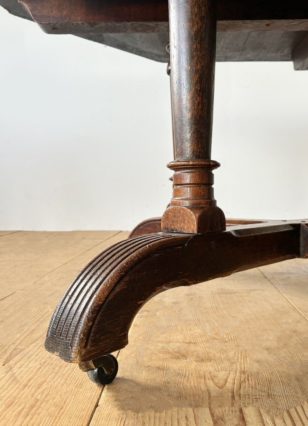 A dark oak Reformed Gothic table with an octagonal top set upon four turned columns and a quadripartite base with castors. View II