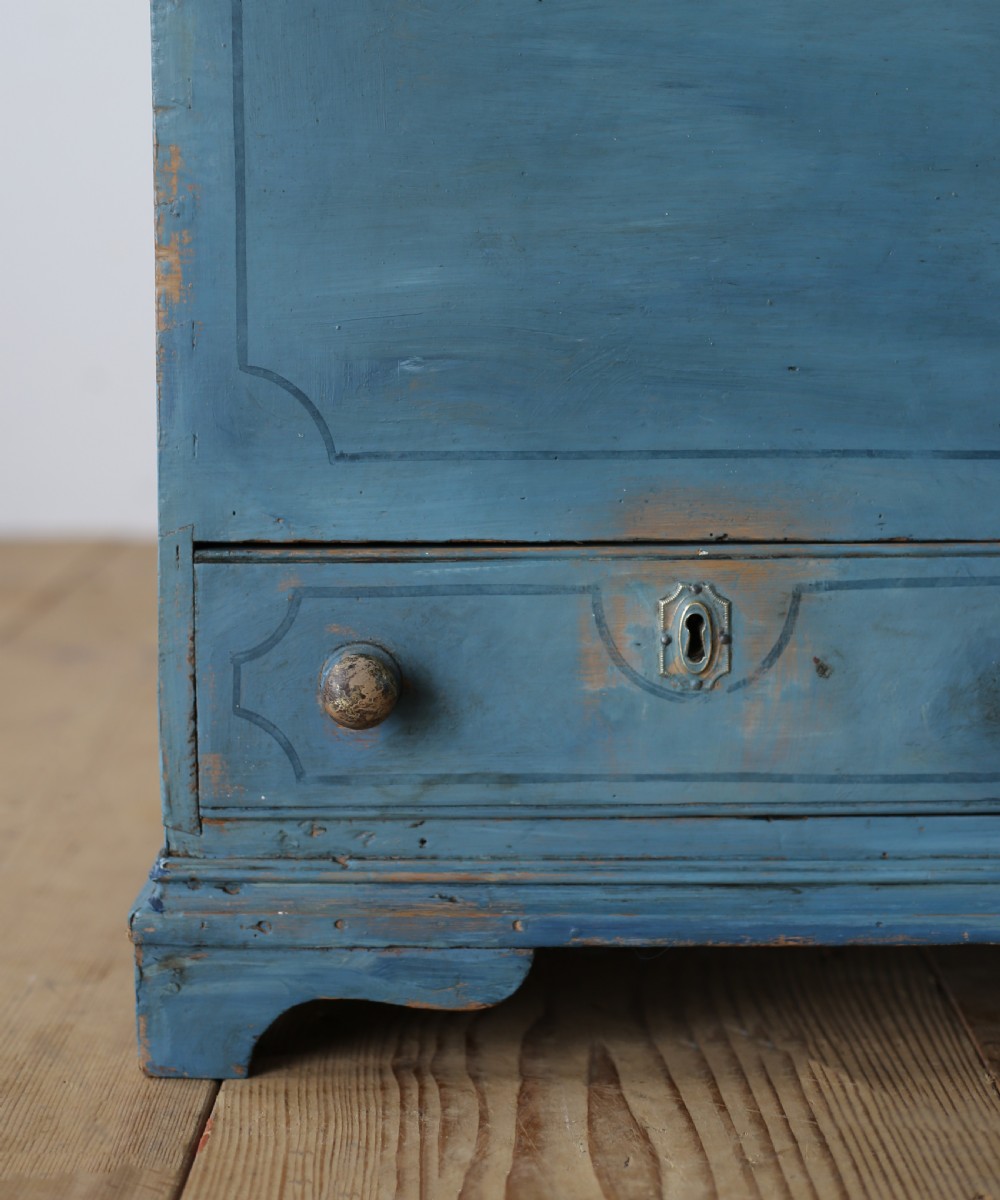 A 19th-century rustic slate blue painted wooden mule chest with a hinged lid top and two drawers with wooden knobs at the base. View II