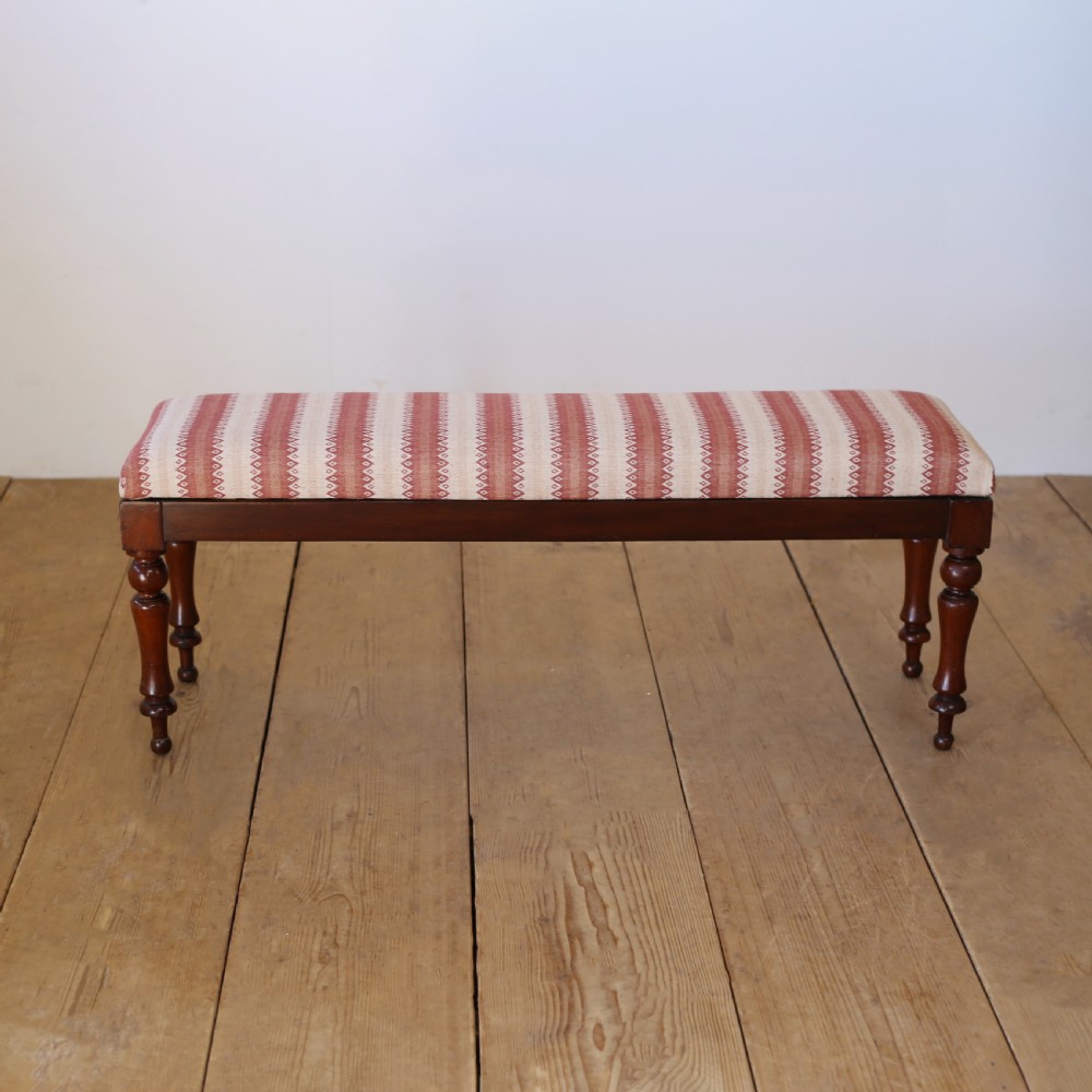 A long rectangular 19th-century window seat featuring a red and cream striped upholstered cushion set upon four turned dark hardwood legs. View II
