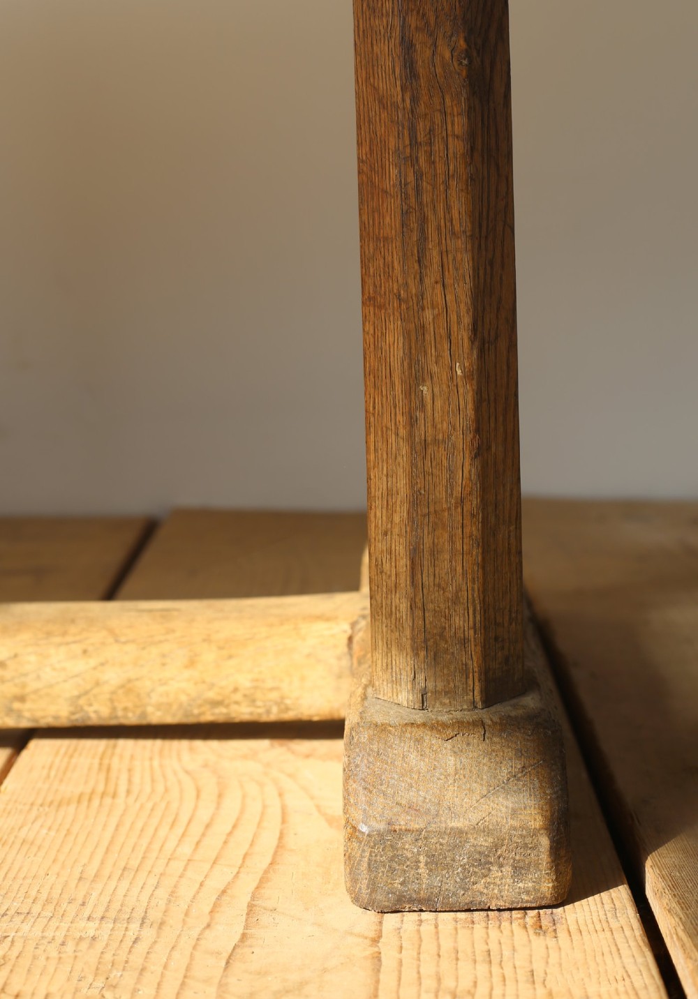 A long solid oak refectory table with a plank top and three sets of square legs connected by a low stretcher rail. View II