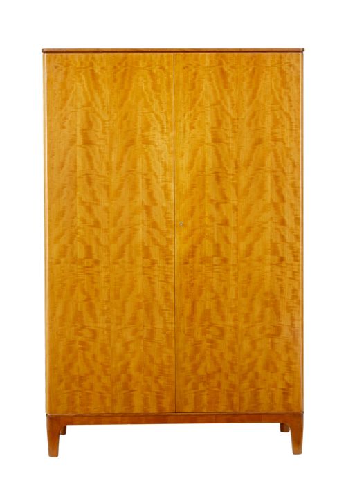 fig 1. A mid-century modern double-door wardrobe crafted from figured golden birch wood with short tapered legs.