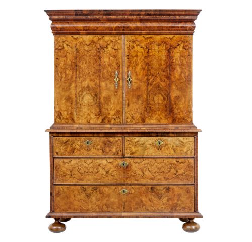 fig 1. An 18th-century George I burr walnut cabinet on chest featuring double upper doors, brass keyhole escutcheons, and turned bun feet.