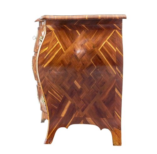 fig 1. An early 18th-century Rococo bombe chest of drawers featuring geometric parquetry inlay in plumwood and three drawers with ornate brass handles.