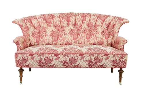 fig 1. An early 20th century three-piece upholstered salon suite featuring a two-seater settee and two matching armchairs with pink and cream floral damask pattern, button-tufted fluted backs, and turned wooden legs with brass castors.