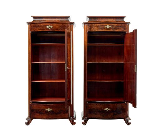 fig 2. A pair of 19th-century Scandinavian tall mahogany cupboards featuring serpentine fronts, flame veneer panels, and ornate brass keyhole escutcheons.