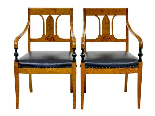 fig 1. A pair of Art Deco Scandinavian birch armchairs featuring curved armrests, ebonised turned supports, inlaid back splats, and black leather studded seats.
