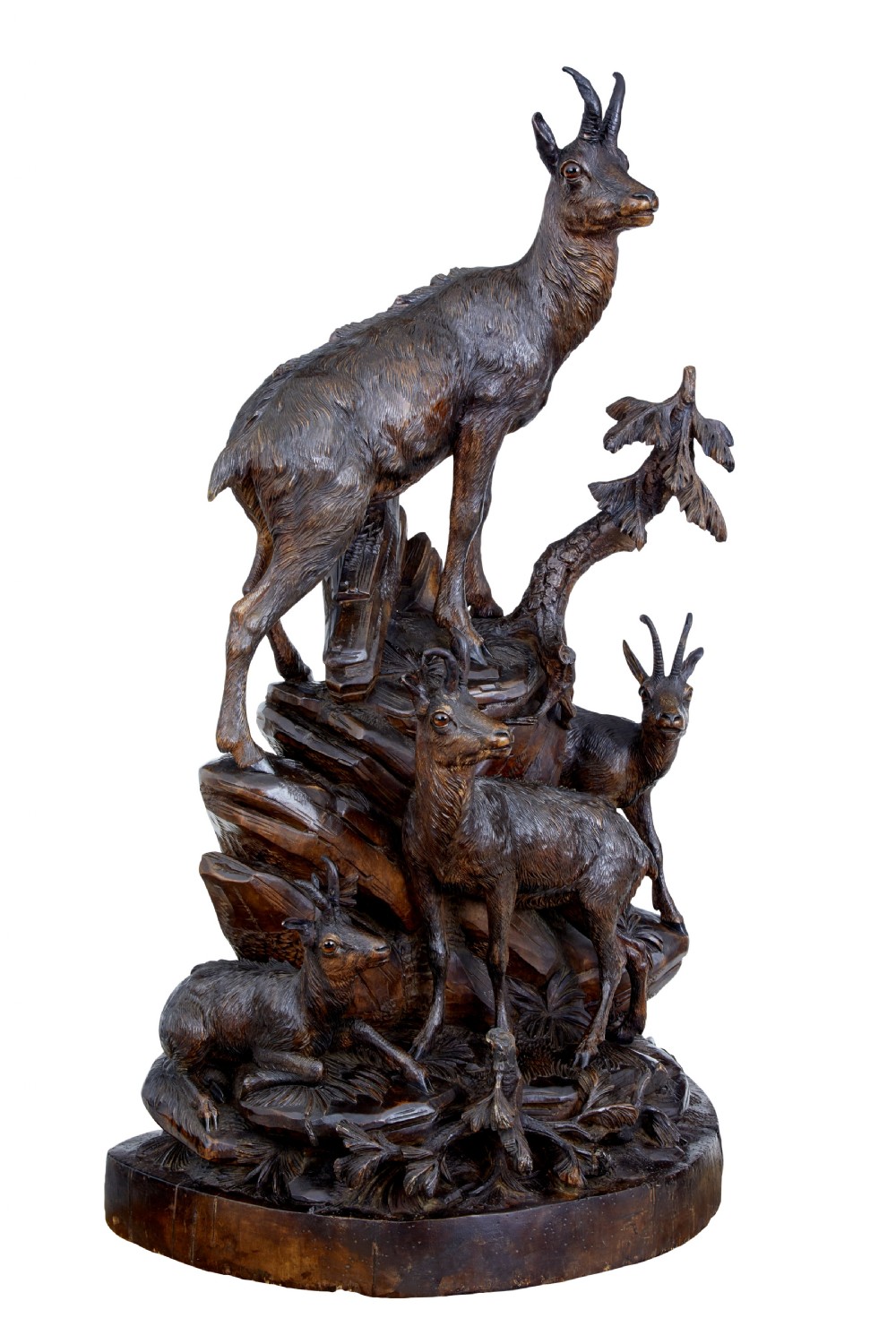 A detailed 19th-century hand-carved linden wood sculpture featuring an alpine ibex standing on a rocky outcrop surrounded by smaller goats. View II