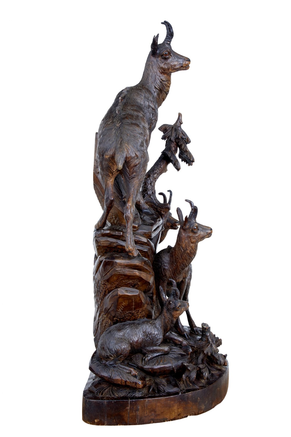 A detailed 19th-century hand-carved linden wood sculpture featuring an alpine ibex standing on a rocky outcrop surrounded by smaller goats. View III