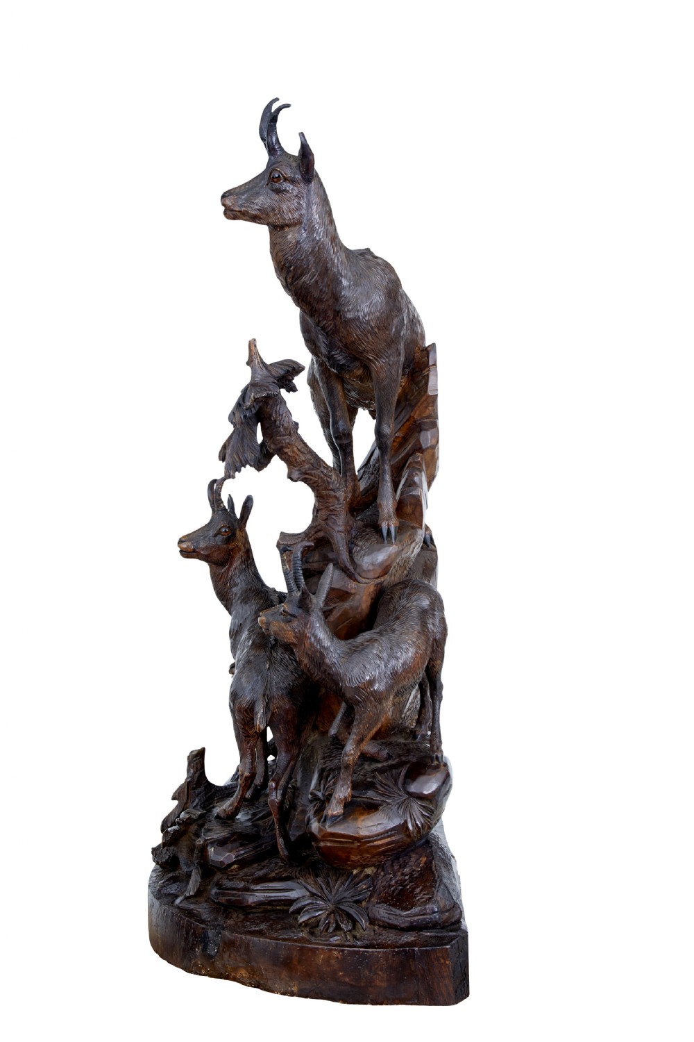 A detailed 19th-century hand-carved linden wood sculpture featuring an alpine ibex standing on a rocky outcrop surrounded by smaller goats. View V