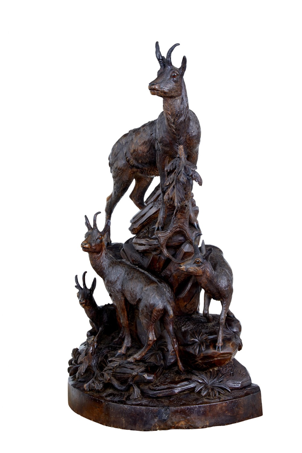 A detailed 19th-century hand-carved linden wood sculpture featuring an alpine ibex standing on a rocky outcrop surrounded by smaller goats. View VI