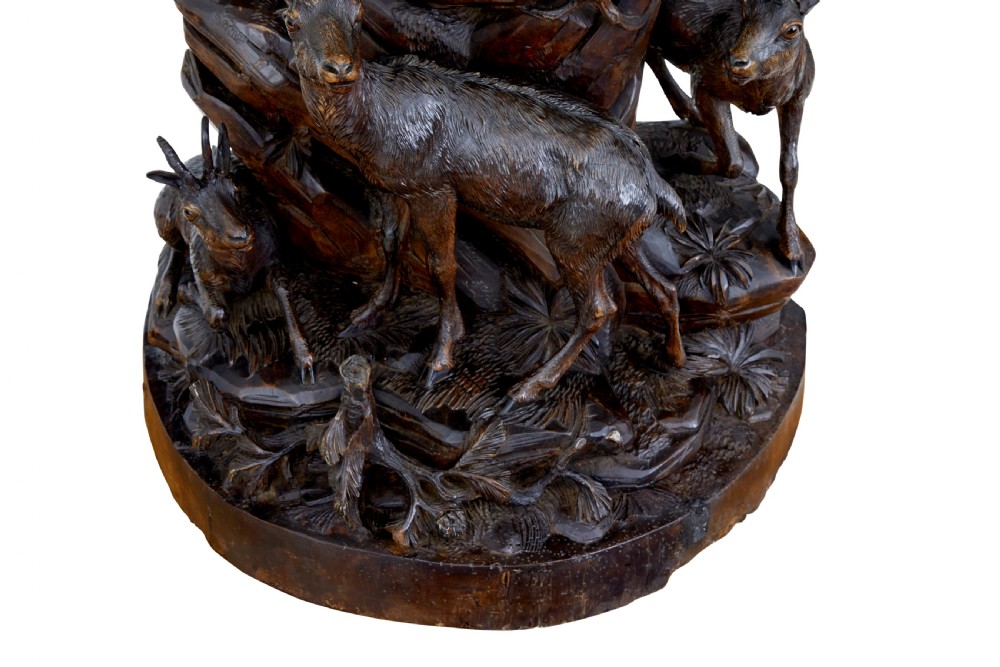 A detailed 19th-century hand-carved linden wood sculpture featuring an alpine ibex standing on a rocky outcrop surrounded by smaller goats. View VIII