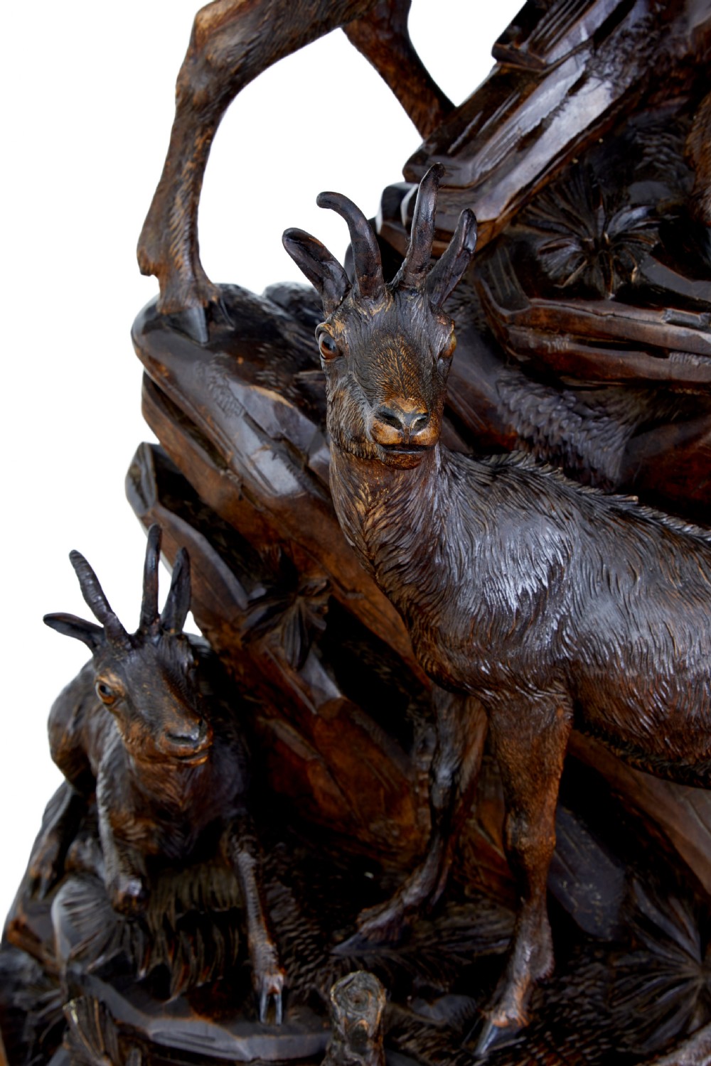 A detailed 19th-century hand-carved linden wood sculpture featuring an alpine ibex standing on a rocky outcrop surrounded by smaller goats. View XI