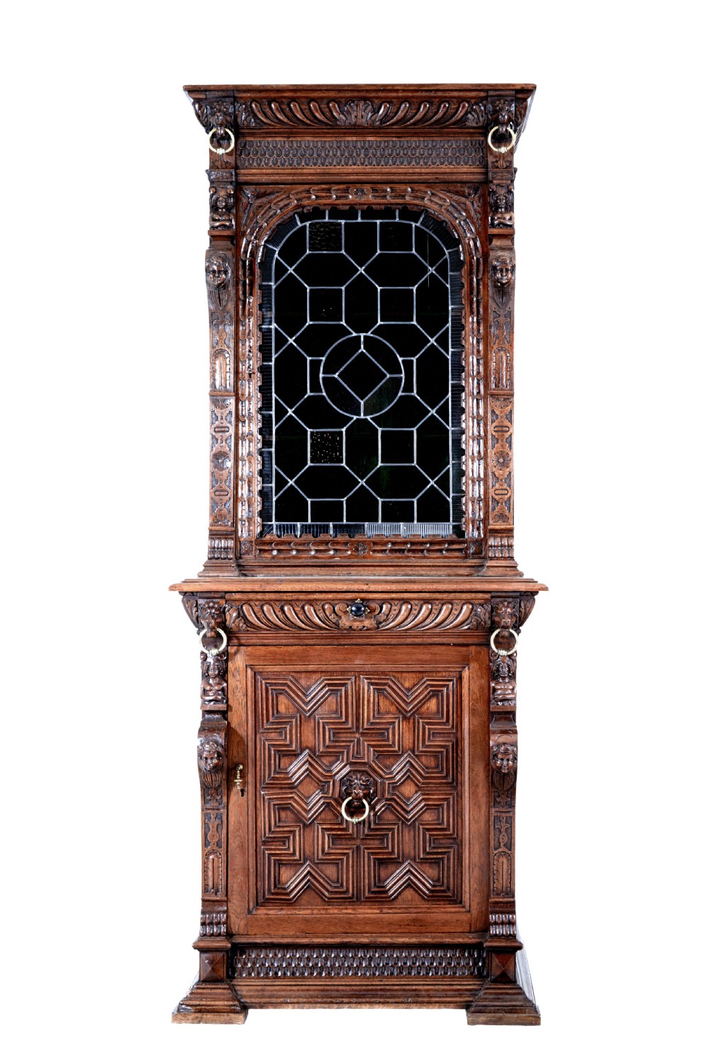 A tall 19th-century Flemish oak cabinet featuring an upper arched leaded glass door and a lower geometric carved wooden door. View II