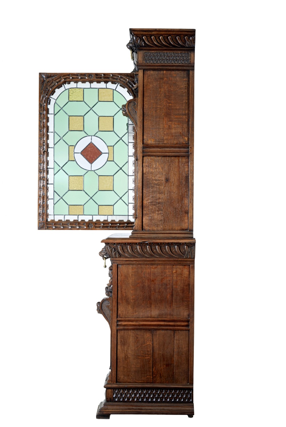 A tall 19th-century Flemish oak cabinet featuring an upper arched leaded glass door and a lower geometric carved wooden door. View V