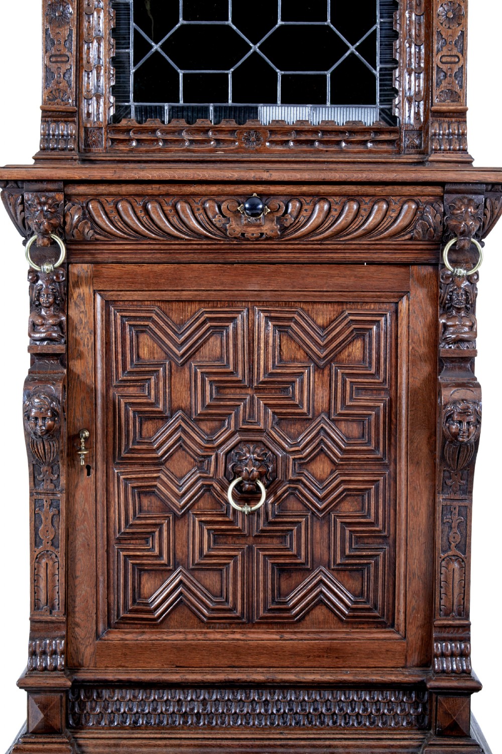 A tall 19th-century Flemish oak cabinet featuring an upper arched leaded glass door and a lower geometric carved wooden door. View VIII