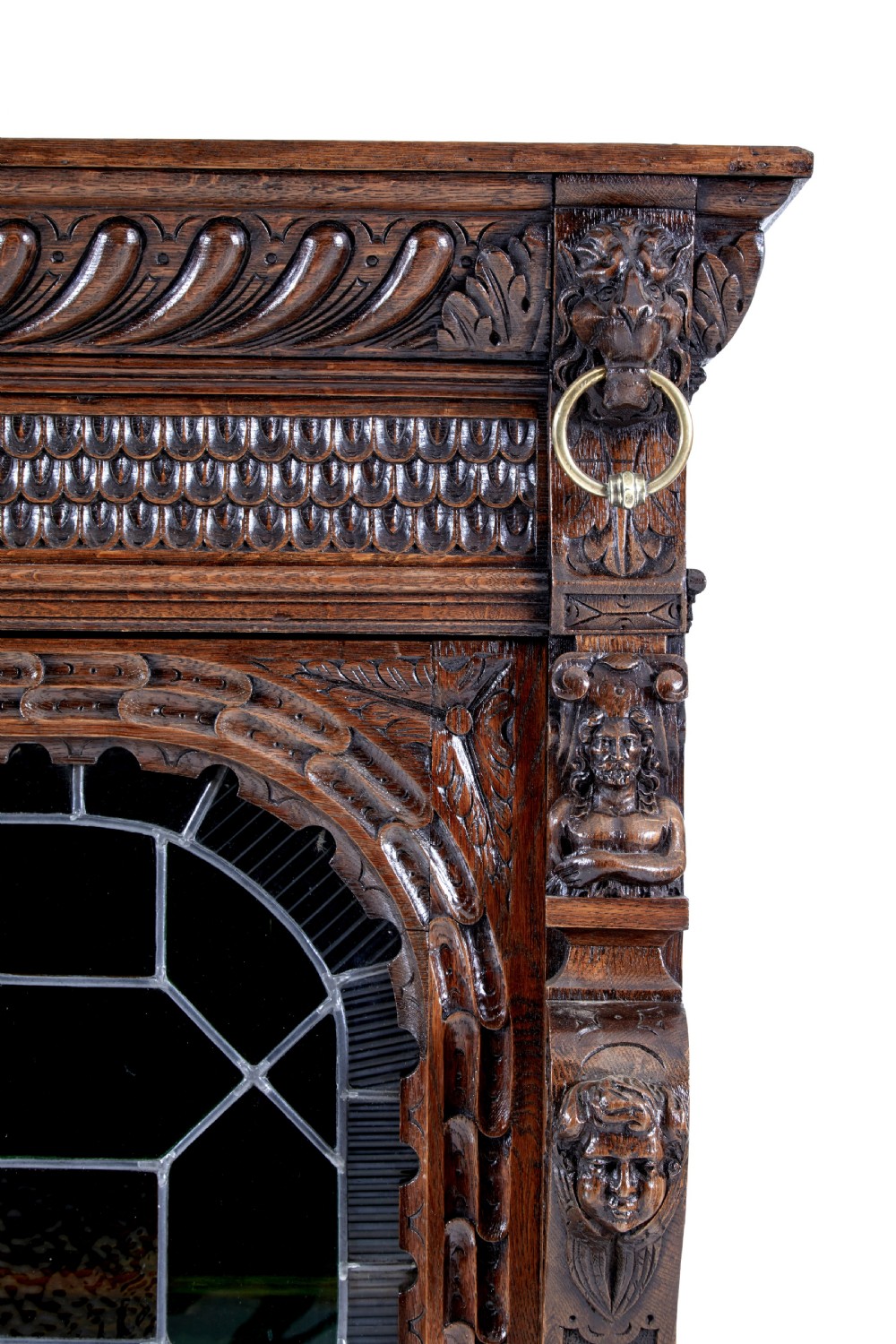 A tall 19th-century Flemish oak cabinet featuring an upper arched leaded glass door and a lower geometric carved wooden door. View IX